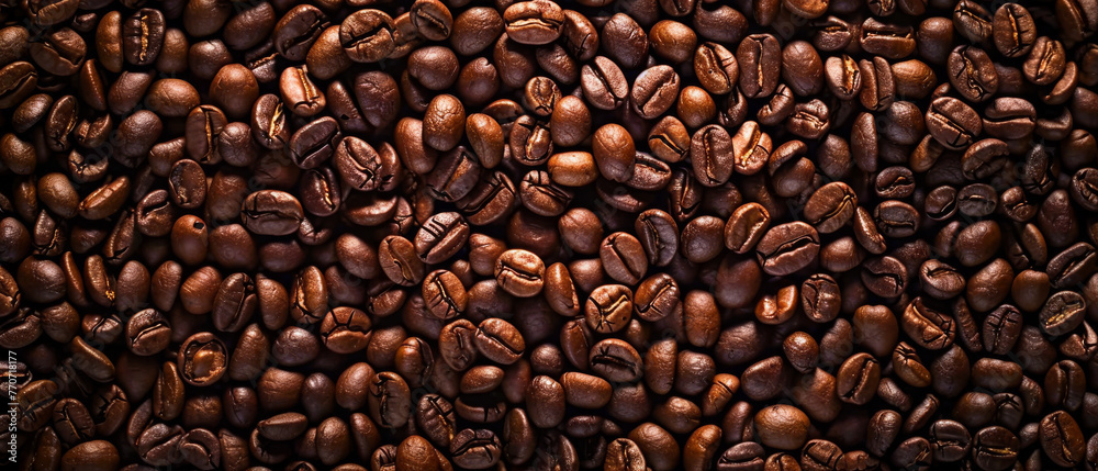 Obraz premium Coffee beans texture for background. Roasted coffee beans on the table for background or design, top view.