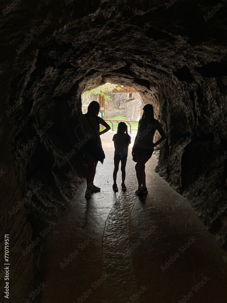 silhouettes of women in a tunnel with natural light in the background silhouettes of women in a tunnel with natural light in the background