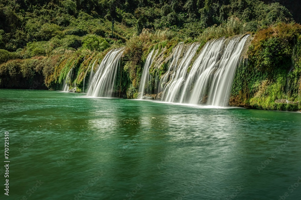 Fototapeta premium View of the Jiulong waterfall streaming down to a lake