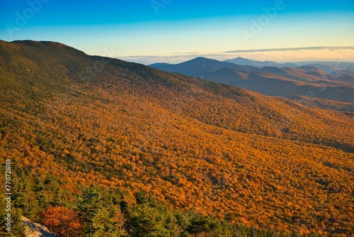 Tranquil scene of the Mount Mansfield landscape with autumnal hues of foliage in Stowe, Vermont photo