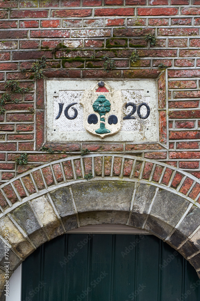 Delft, the Netherlands. 17th century sign on the old building stating the construction date year 1620.
