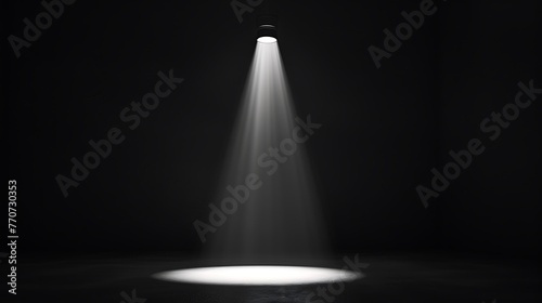 A spotlight shines down on an empty stage. The spotlight is bright and focused, creating a pool of light on the stage.