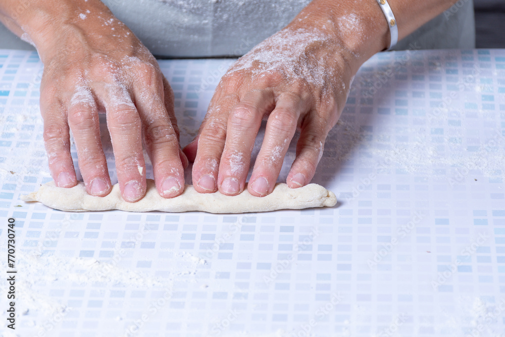 Woman's hands making rolls with the dough. Woman's hands making rolls with the dough.