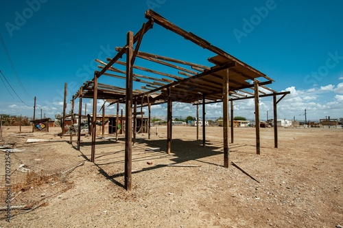 a wooden structure is standing in an empty land with dirt