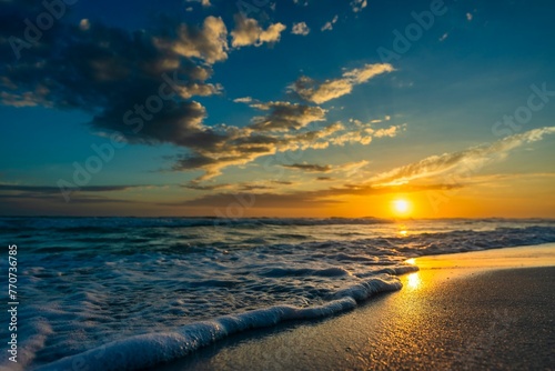 a beach with a bunch of waves at sunset and clouds