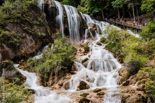 Scenic view of a forest with a waterfall and lake in Jiuzhaigou, Sichuan Province, China.