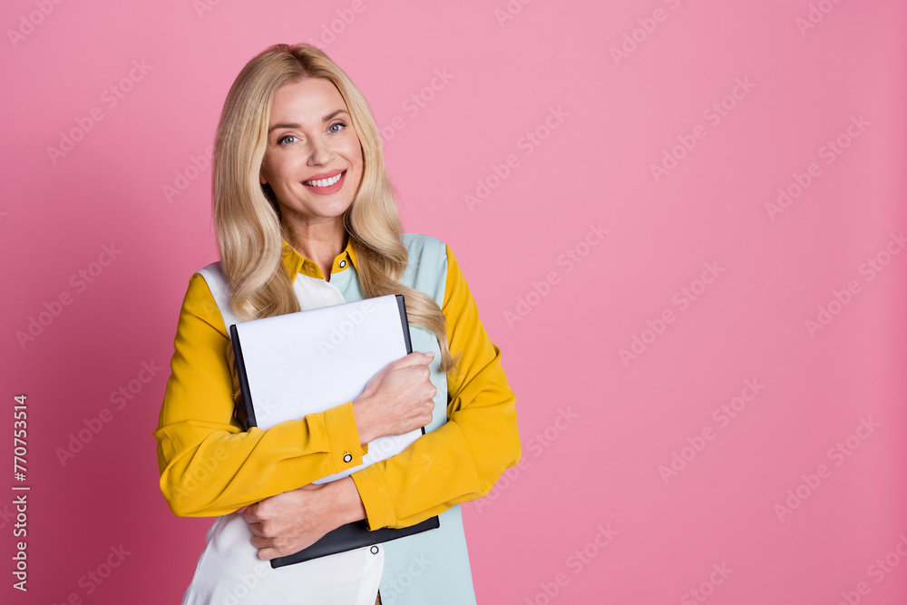 Photo of charming adorable pretty woman wear trendy clothes hold document stand empty space isolated on pink color background Photo of charming adorable pretty woman wear trendy clothes hold document stand empty space isolated on pink color background