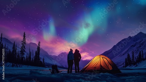 Couple camping in wild with tent and stunning aurora light at night.
