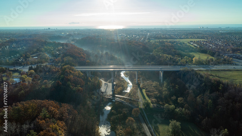 An aerial view at sunrise of a bridge going over a valley and River