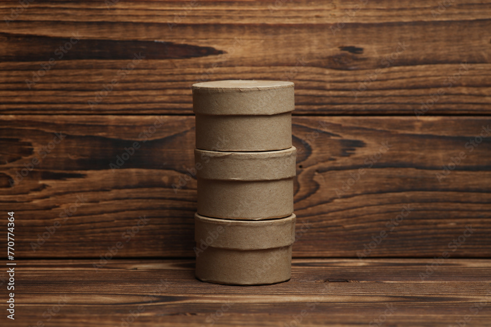 Round craft cardboard boxes for product on wooden background Round craft cardboard boxes for product on wooden background