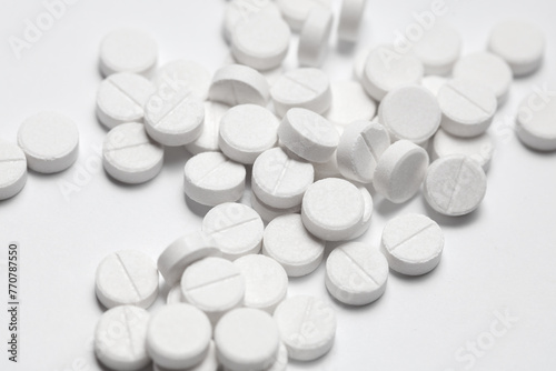 Close-up of white pills on a white background. Medicine concept