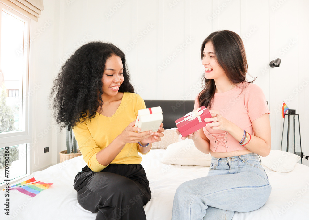 A multiracial young lesbian couple happily exchanging surprise gifts on special days such as anniversaries, Valentine's Day, New Year's Day, Christmas Day, birthdays, or congratulations A multiracial young lesbian couple happily exchanging surprise gifts on special days such as anniversaries, Valentine's Day, New Year's Day, Christmas Day, birthdays, or congratulations