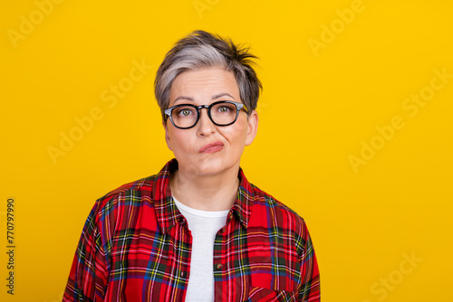 Photo of unsatisfied minded aged lady sullen face empty space isolated on vivid yellow color background