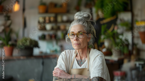 Wallpaper Mural Senior hipster woman with glasses in an apron poses in a plant-filled room.. Torontodigital.ca