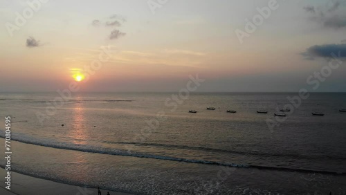 Sunset Beach in Bali, Indonesia. Badung City. Ocean Water and Tourists in Background. Popular Spot Among Tourists and Local People photo