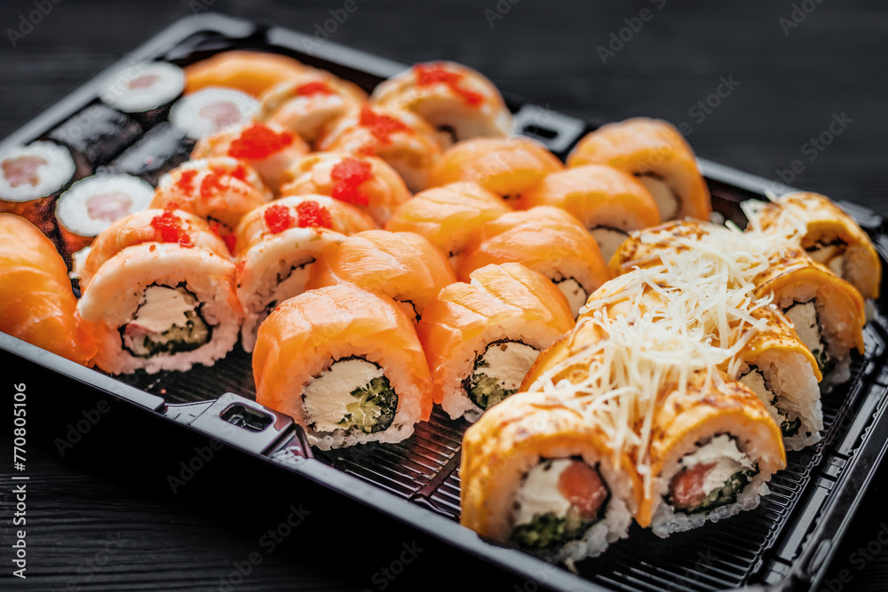 Sushi set with salmon on a black background, top view Sushi set with salmon on a black background, top view
