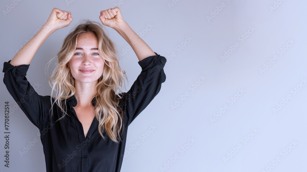 Naklejka premium Blonde businesswoman wearing black shirt, smiling and raised hands