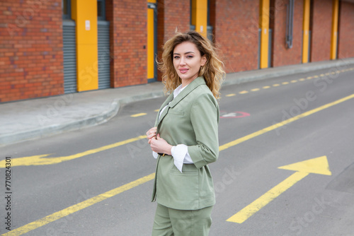 Portrait of a successful business woman in front of modern business building.Young manager poses outside. Female business leader.  © romeof
