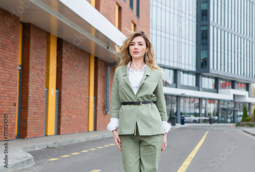 Portrait of a successful business woman in front of modern business building.Young manager poses outside. Female business leader.
