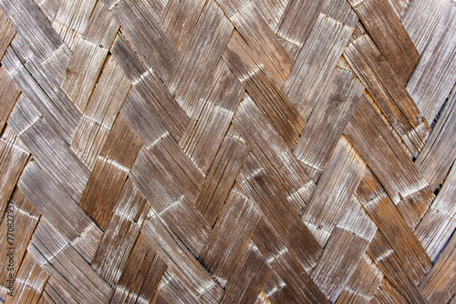 Photography A close up view of a handmade woven bamboo mat with a brown background
