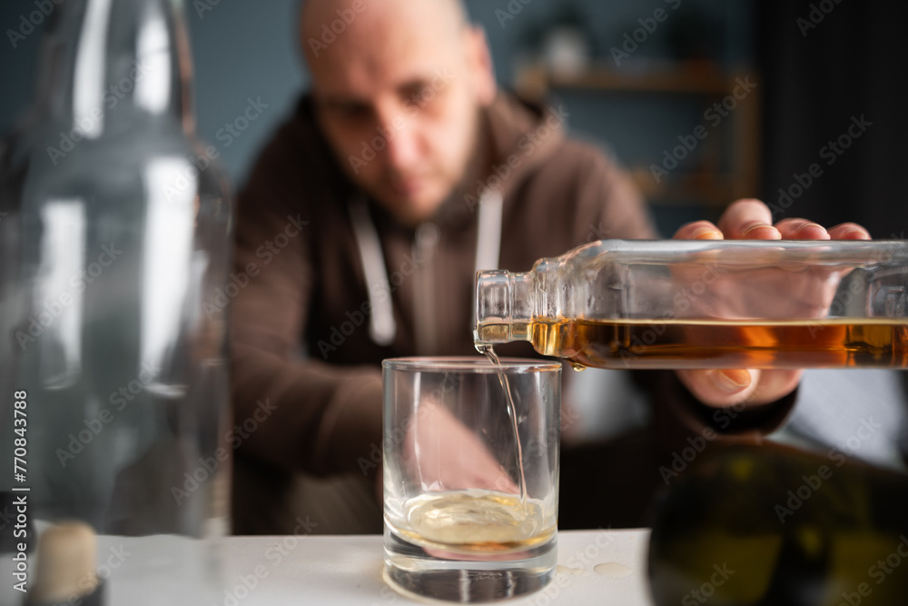 Alcoholism concept. Sad depressed man drinking alcohol, pouring whiskey in glass.