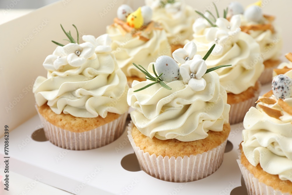 Tasty Easter cupcakes with vanilla cream in box, closeup Tasty Easter cupcakes with vanilla cream in box, closeup