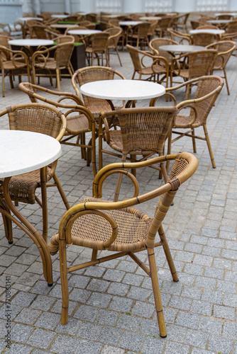 A cozy outdoor cafe with elegant wicker furniture on a paved sidewalk