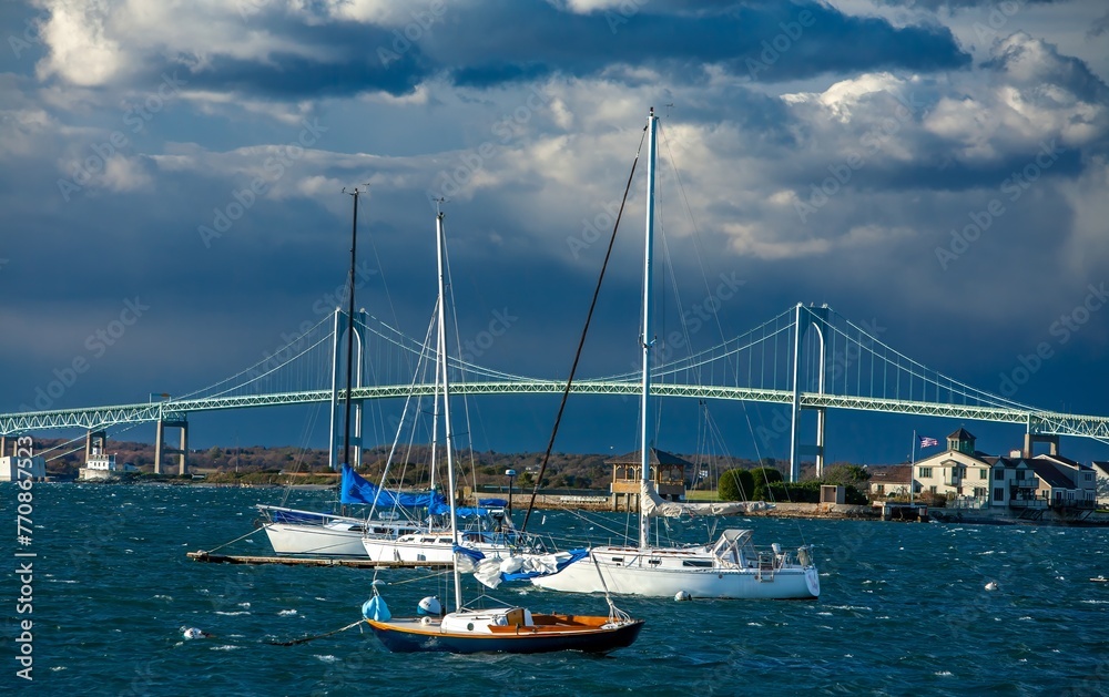 Sailboats and pleasure crafts are docked within sight of the Newport Pell bridge, connecting Jamestown and Newport, Rhode Island