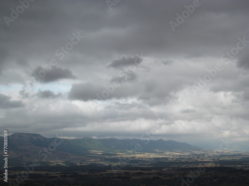 cantabrian mountain range on a cloudy rainy day  and green fields photo