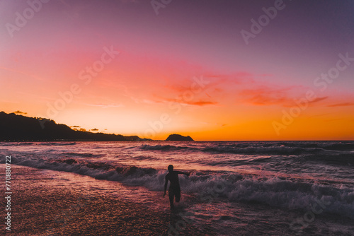 person running excited  orange, pinksunset on the beach © Iloui