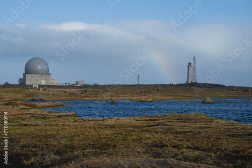Radar station and lighthouse with a rainbow on stokksnes peninsula, iceland, in summer