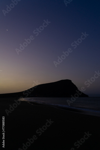 la Tejita beach sunrise in blue hour with the silhouette of the hill, the sand  and the ocean photo