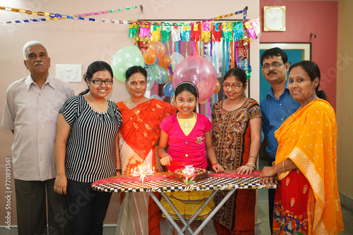 A girl celebrating 12 years birthday with family members in a house photo