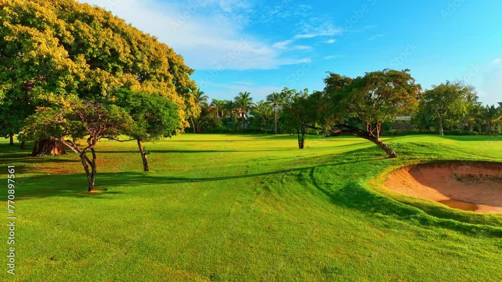 Tropical landscape of a lawn with green grass in the Dominican sports park. Panoramic views of the golf course. Green golf course next to the hotel. Vacation and outdoor recreation concept. Tropical landscape of a lawn with green grass in the Dominican sports park. Panoramic views of the golf course. Green golf course next to the hotel. Vacation and outdoor recreation concept.