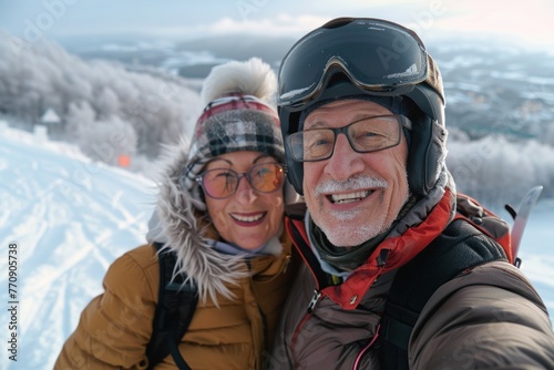 Selfie portrait of senior active smiling mature couple sledding skiing in glasses look happy on top of mountains