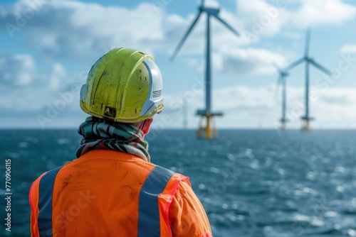 An engineer looks at an offshore wind farm in the sea photo