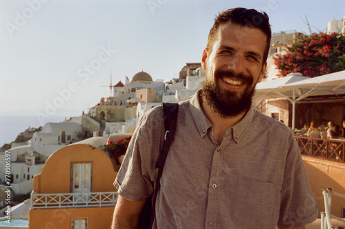 Film portrait of a happy tourist man visiting Santorini