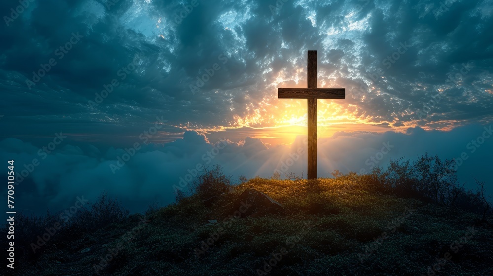   A cross atop a hill, sun shining through scattered clouds above