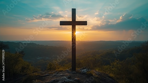  A cross atop a hill, bathed in sunlight filtering through distant clouds Trees dot the foreground