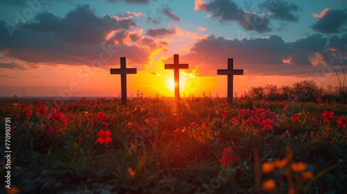  A pair of crosses in a flower-filled field at sunset, with the sun sinking behind them