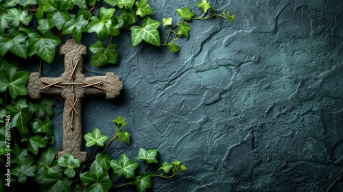   A cross atop a stone wall, overgrown with green ivy climbing its side, adheres to a building photo