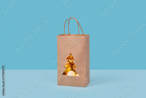 Papercraft package filled with glowing garlands and gold baubles