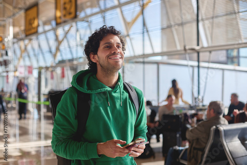 A young smiling man lookinng and exploring the airport. photo