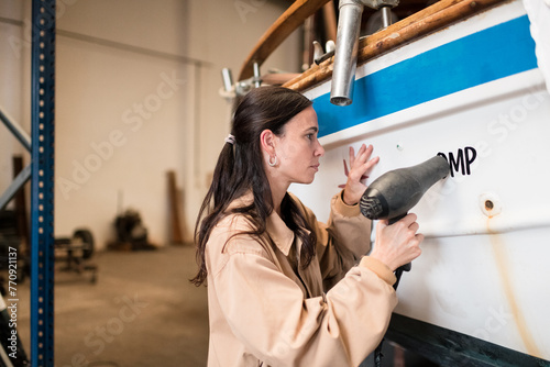 Focused woman working on boat maintenance photo