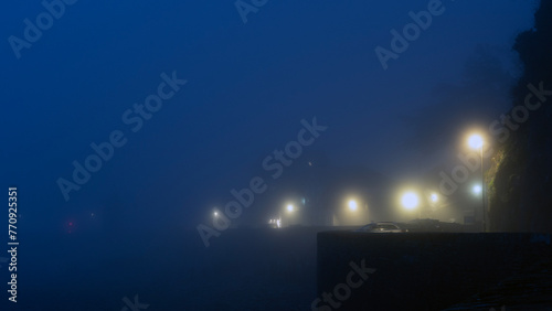 Dark foggy night with glowing street lights  photo