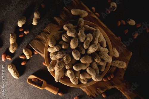 Dried peanuts in a shell in a wooden plate