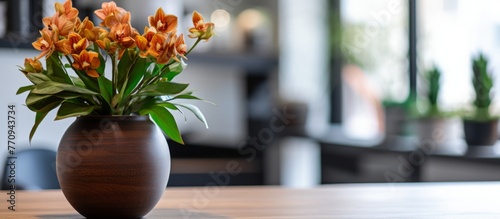 A vase filled with orange flowers is placed on a wooden table, adding a pop of color to the room. The vibrant petals brighten up the space photo
