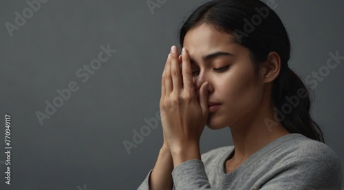 Create a compelling and emotionally charged 8K resolution image of a woman covering her face with her hand. The composition should focus on capturing a moment of vulnerability or introspection, using 