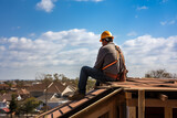 couvreur travaillant sur la toiture d'une maison endommagée par une tempête, charpentier de dos avec EPI, sur le toit d'une maison avant pose des tuiles, village et ciel en arrière-plan copy space.
