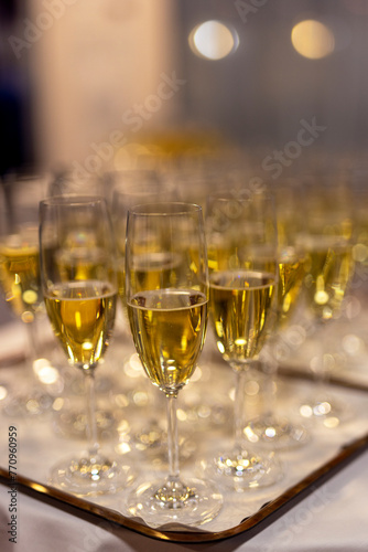 tray with poured glasses of yellow champagne with bubble for a toast for a celebration or Christmas and New Year photo